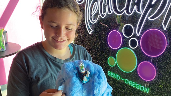 Tween looks at cotton candy on top of drink