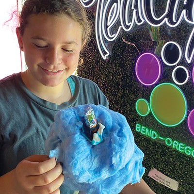 Tween looks at cotton candy on top of drink