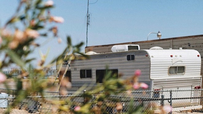 RV on the street behind a chain link fence