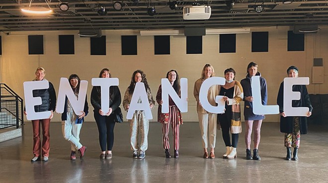 People hold "Entangle" written in individual letters