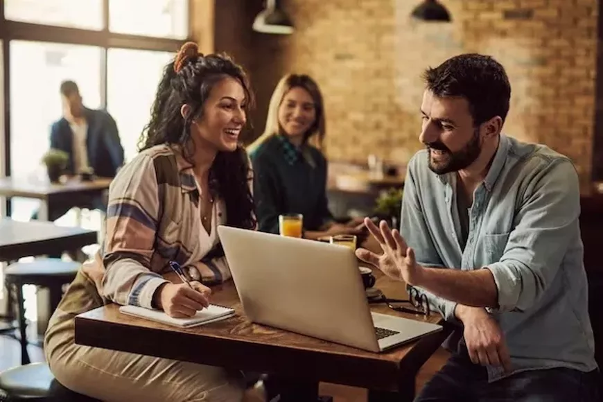 happy-couple-talking-while-working-laptop-cafe_637285-12505_copy.webp
