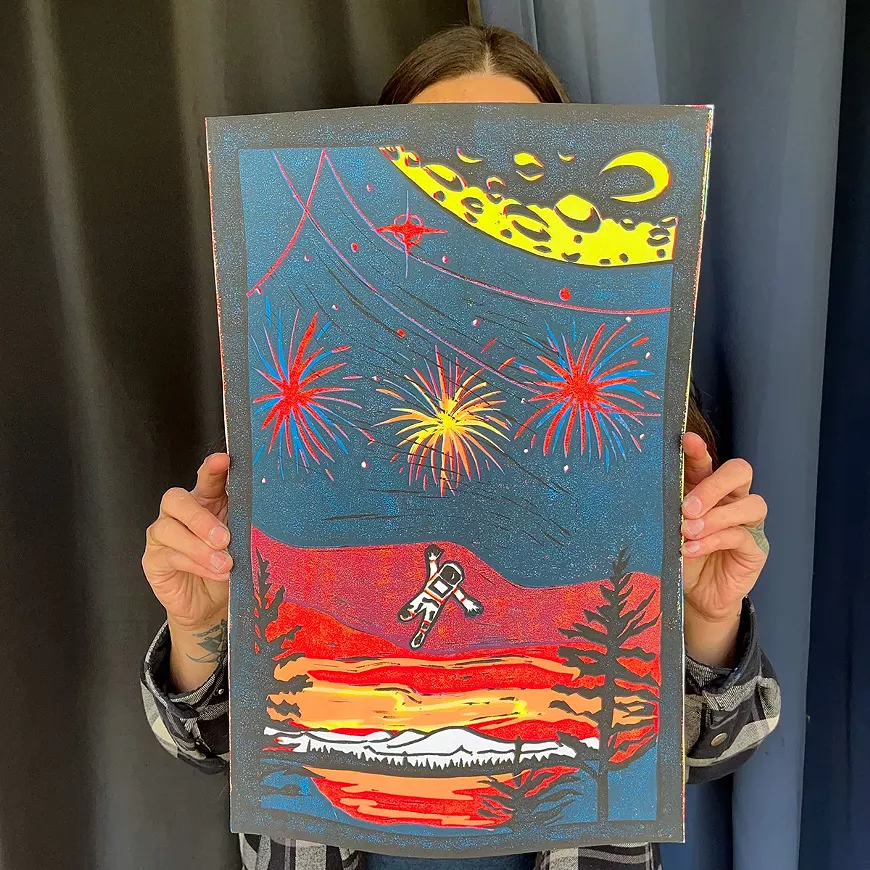 Printmaker Anne Pick holding her original, block-printed poster "Roman Candles".
