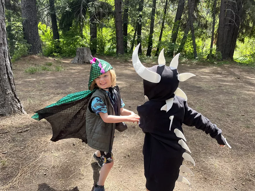 kids playing in dragon costumes in the woods