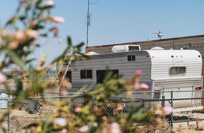 RV on the street behind a chain link fence